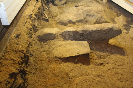 Tuvan lattian alta paljastuneita kivirakenteita